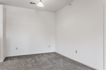 An empty room with carpet and white walls